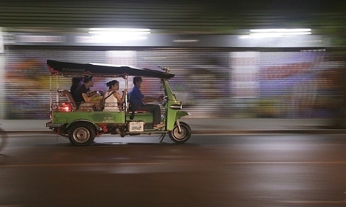 A Tuk-tuk taxi driver speeding in Bangkok, Thailand. 