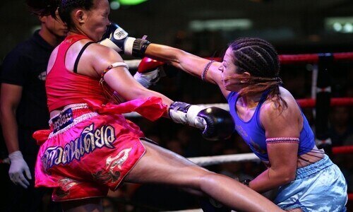 Two female Muay Thai fighters in action. 