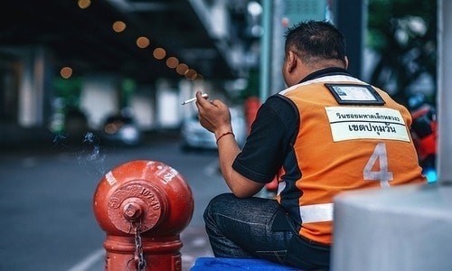 A motorbike taxi driver with his orange vest. 
