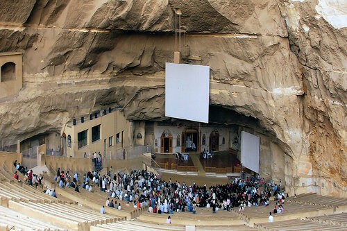 The Cave Church of St. Simon in Egypt with people attending in it