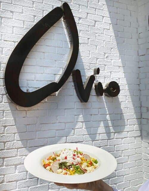 A picture of Ovio's logo on a wall along with a dish full of food