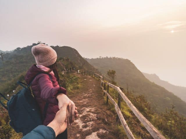 A couple hiking and viewing a beautiful landscape as part of slow travel.