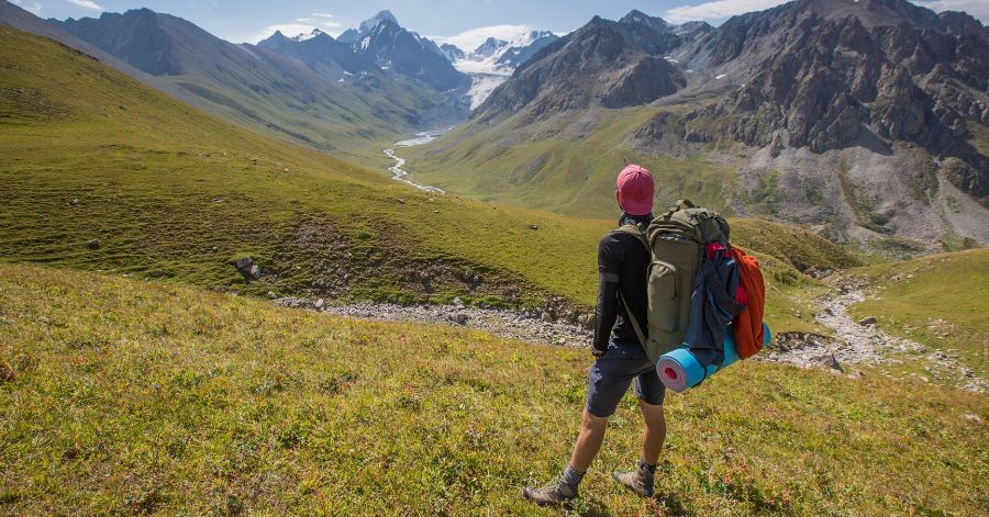 A man backpacking on a mountain as a slow travel activity