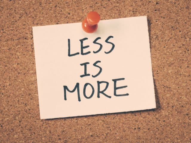 A picture of a post-it note with the words "LESS IS MORE" written on it.