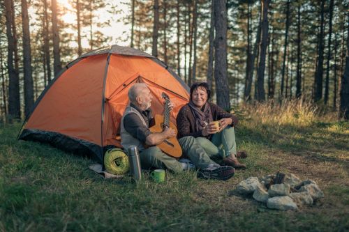 A picture of an elder couple camping in the woods.