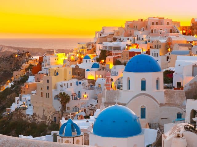 A picture of the beautiful blue buildings in Santorini, Greece which is a slow travel destination.