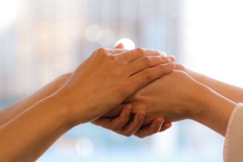 A picture of two women holding hands to indicate having a deep connection.