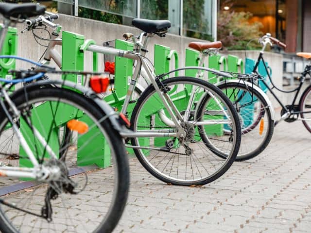 A picture of several bikes parked at an electric bikes station.