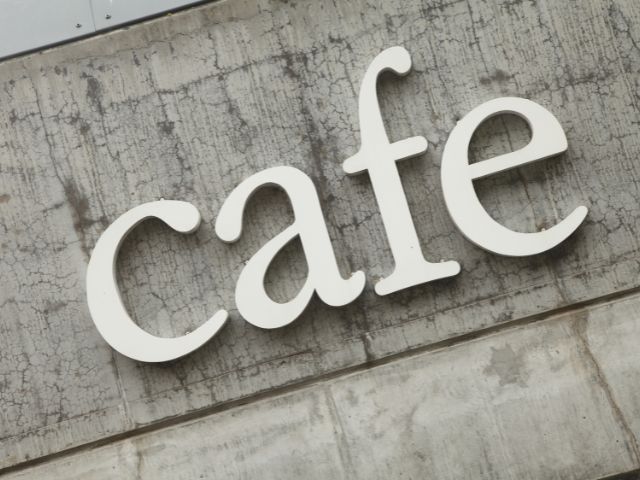 A picture of the word cafe written on a wall.