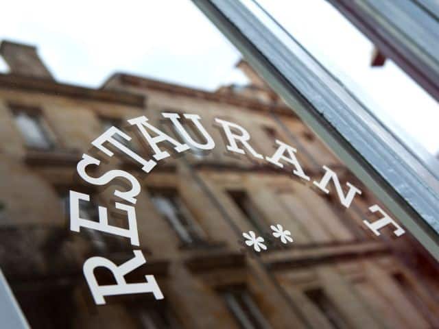 A picture of the word restaurant written on a glass door.