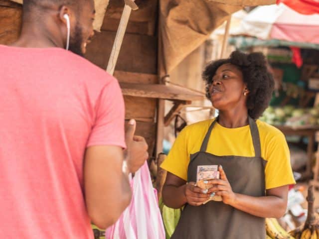 A picture of a man and a woman bargaining about prices in a shop.