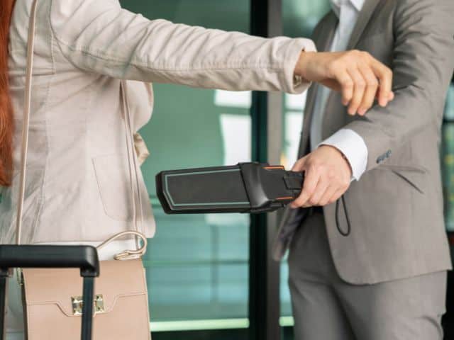 A picture of a woman going through a security check.