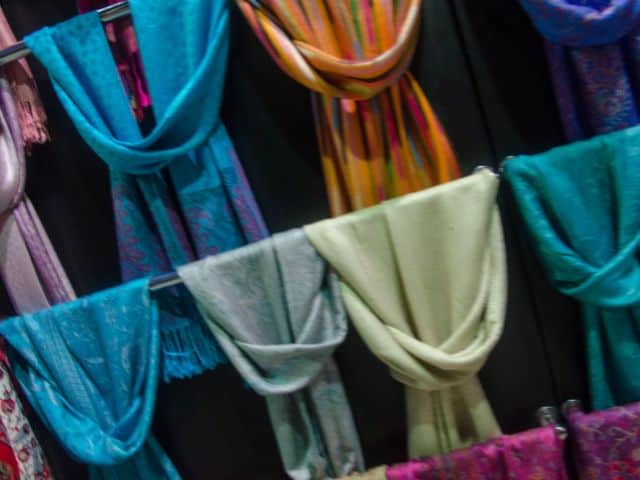 A picture of several colorful head scarfs in a shop.