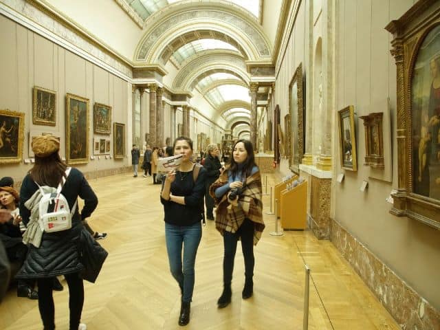 A picture of people on a tour inside of the Louvre Museum in Paris, France.