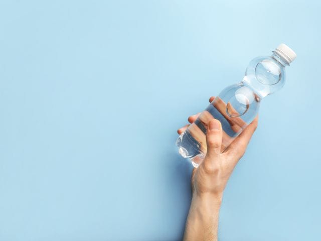 A picture of someone holding a water bottle on a blue background.