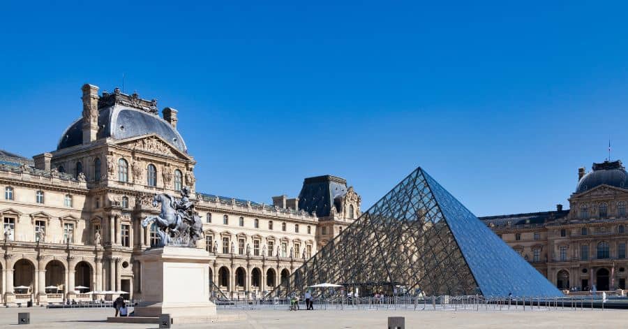 A picture taken during daylight outside of the Louvre Museum in Paris, France.