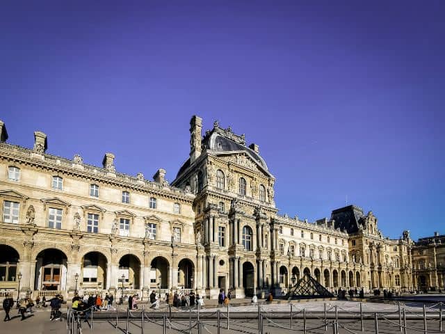 A picture showing the exterior of the Louvre Museum in Paris, France.