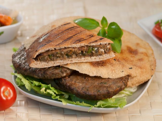 A picture of Egyptian Hawawshi in a plate with some salad.