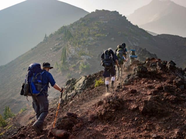 A picture of a group of people hiking on top of a mountain.