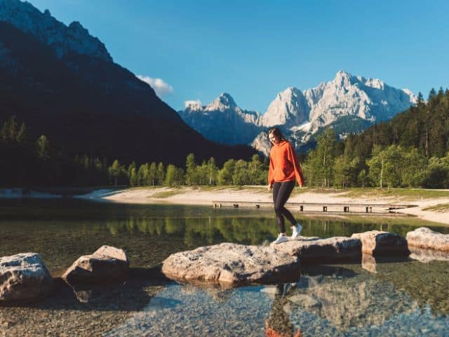 A picture of a woman walking by a lake.