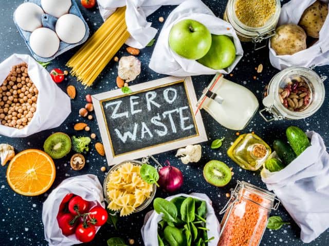 A picture of the words zero waste written on a chalkboard that is surrounded with food.