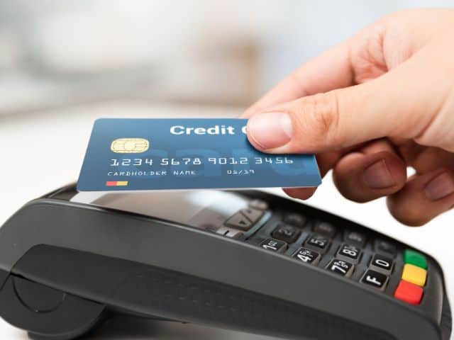 A picture of a man using a credit card to pay.