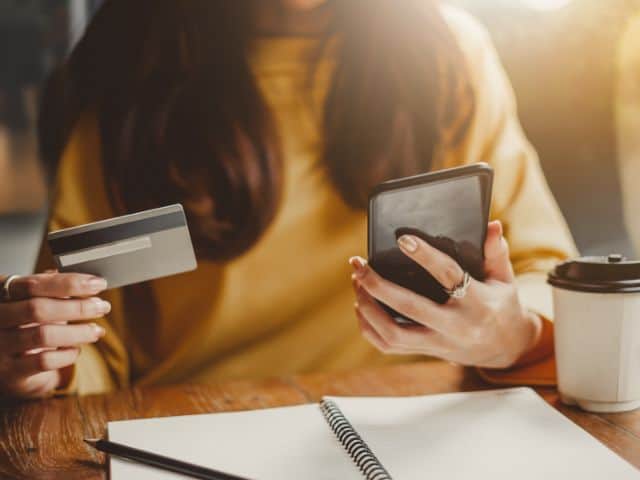 A picture of a woman using a credit card.