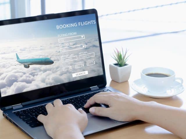 A picture of someone booking flight on a laptop.