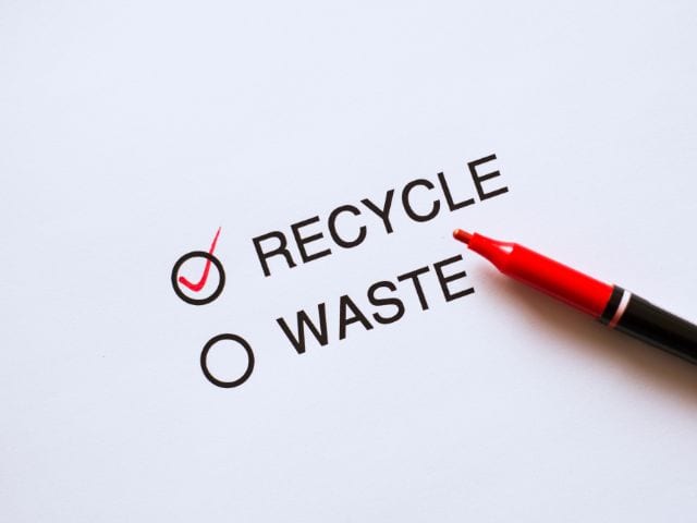 A picture of the words "recycle" and "waste" on a white background with a right red mark next to "recycle"