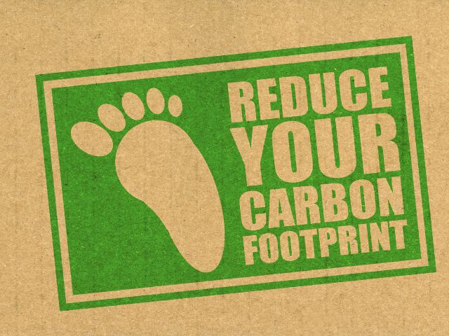 A picture of the words "reduce your carbon footprint" on a foot stamp.