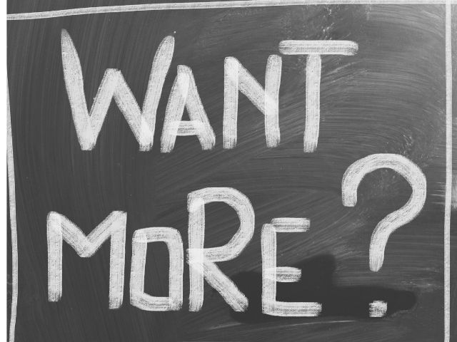 A picture of the words "Want more?" written on a blackboard.