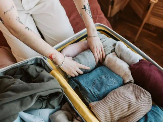 A picture of a person packing a travel bag.