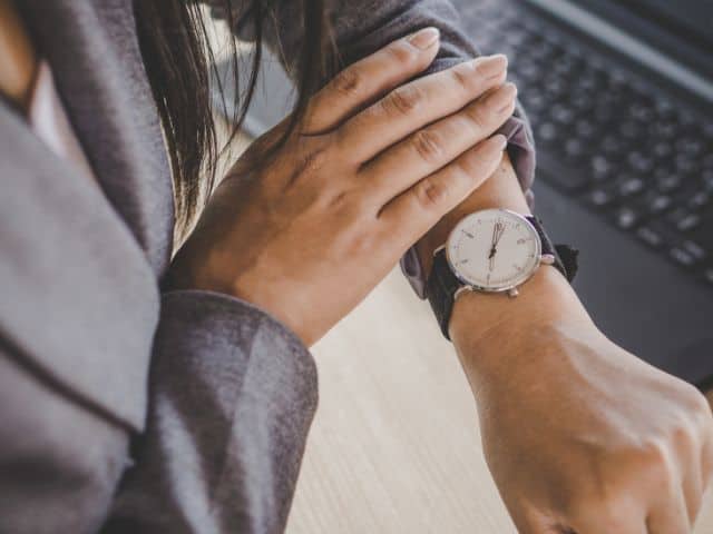 A picture of a woman checking her watch.