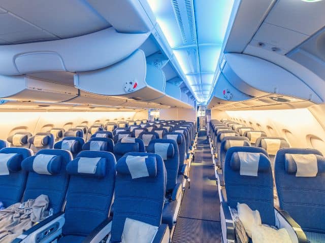 A picture of several rows of seats inside an airplane.