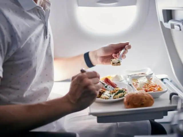 A picture of someone eating a meal inside a plane.