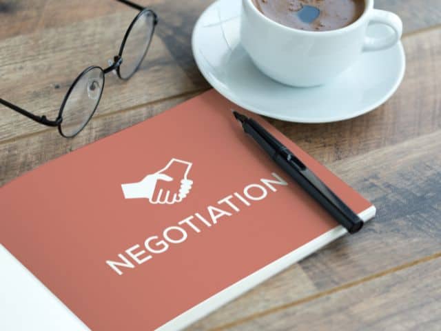 A picture of the word negotiations written on papers.