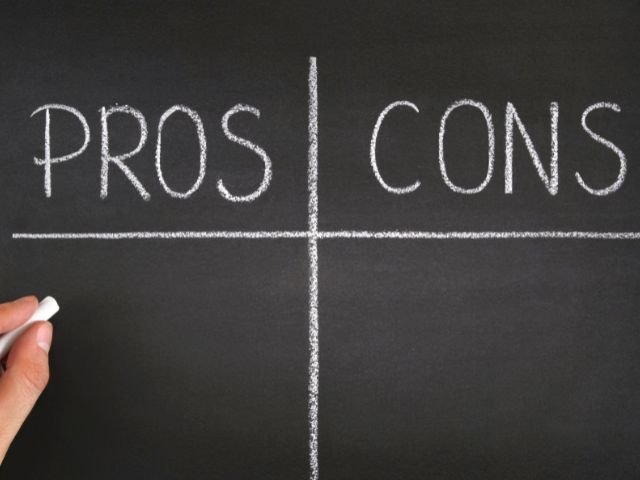 A picture of the words "pros" and "cons" written on a blackboard.